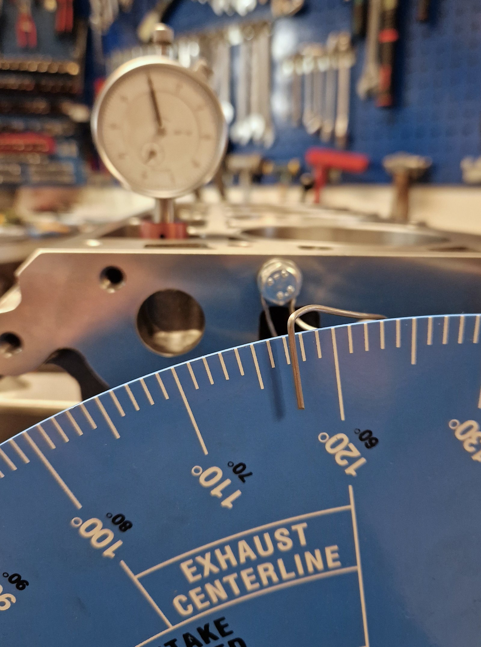 Close-up of a gauge with measurement markings in a workshop setting.